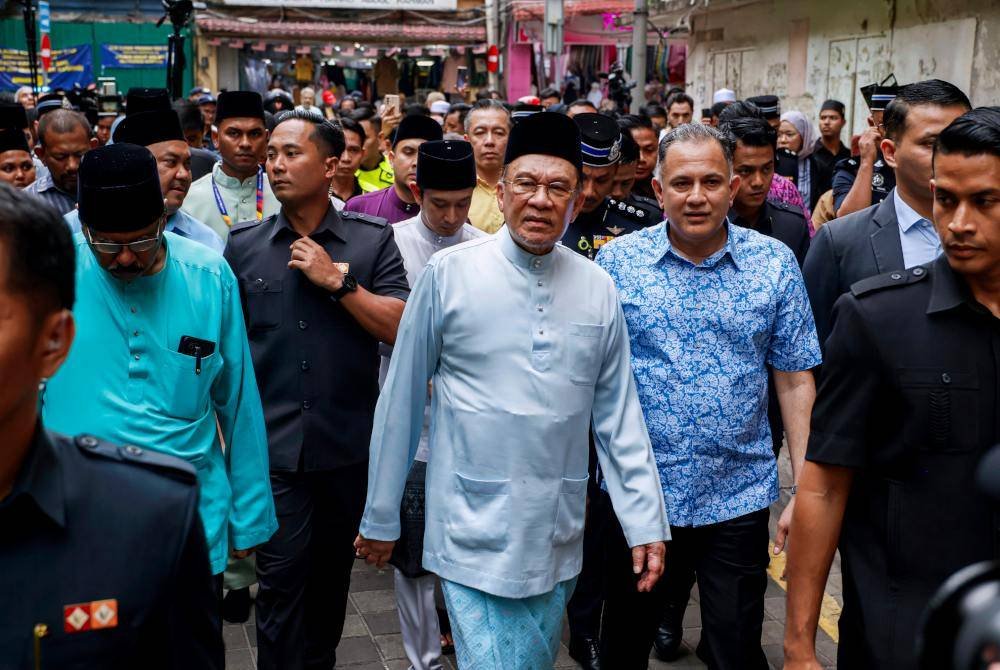 Anwar meninjau di sekitar Jalan Masjid India selepas menunaikan Solat Jumaat di Masjid India pada Jumaat. Foto Bernama