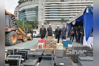 Dari kiri, Rosli, Ku Mashariman dan Mohd Sabri menyaksikan barang rampasan yang akan dilupuskan oleh IPD Brickfields pada Jumaat. Foto HISYAMUDDIN AYUB.