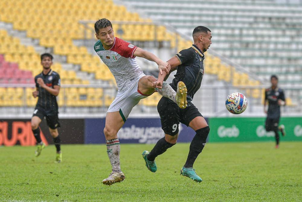 Tonggak PDRM, Bruno Suzuki (kanan) diasak pemain Kuching City, Yuki Tanigawa pada Liga Super di Selayang.