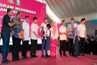 Anwar (lima dari kiri) menyampaikan sumbangan barangan keperluan sekolah kepada pelajar pada Program Muhibbah Madani 2025 di Bukit Mertajam pada Sabtu.