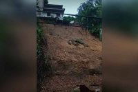 Tanah runtuh yang berlaku di belakang sebuah rumah susulan hujan lebat berterusan pada Sabtu. Foto tangkap layar video orang awam