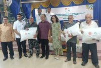 Yujing (tengah) bergambar bersama penerima yang juga mangsa banjir pada majlis penyerahan bantuan kemanusiaan di SK Pulau Rusa.