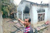 Khairuzzaman menunjukkan rumah jirannya di Kampung Charuk Kapas, Kupang, Baling yang terbakar.