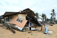 Penduduk, Mohd Shameer Talib, 33, melihat keadaan struktur rumahnya yang separuh runtuh akibat dipukul ombak besar serta fenomena air pasang besar ketika tinjauan di Kampung Geliga Baru pada Isnin. Foto Bernama