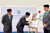 Abdul Aziz (tengah) menandatangani plak semasa Majlis Perutusan Pengerusi MAIS 2025 di Auditorium Dahlia pada Selasa.