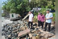 Aznan (kiri) meninjau kawasan yang terkesan akibat hakisan ombak di pekan Sungai Rengit pada Selasa.