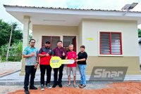 Seng Chong (dua dari kanan) menerima replika kunci sebagai gimik penyerahan rumah baharu daripada Yayasan Perak di bawah Program Sayangi Rumahku.