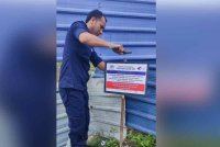 Seorang kakitangan Jabatan Perikanan Selangor menampak notis amaran berhubung aktiviti mengambil anak kerang.