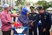 Mohd Khairi (kanan) beramah mesra dengan seorang penunggang motosikal ketika Kempen Keselamatan Jalan Raya Tahun Baru Cina 2025 Peringkat Negeri Terengganu di Dataran Shah Bandar, Kuala Terengganu pada Ahad.