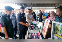 Hamzah (tengah) ketika melawat gerai pameran Program Gempur Dadah di ILP Kepala Batas pada Isnin.