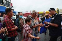 Vijaya (kanan) beramah mesra bersama pengunjung ketika program walkabout sempena Tahun Baharu Cina di Pasar Pagi Eng Ann pada Selasa.