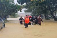 Anggota Jabatan Bomba dan Penyelamat Malaysia (JBPM) Bintulu membantu mangsa banjir di Taman Bandar Jaya Lorong Alamanda. Foto Bernama