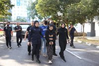 Pasangan kekasih berkenaan diiringi anggota polis sebaik tiba di pekarangan mahkamah.