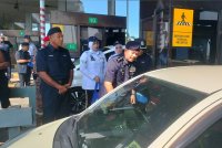 Hamzah (kanan) menyampaikan beg kepada pengguna jalan raya sempena Program Advokasi sempena Op Selamat 23/2025 Tahun Baharu Cina Peringkat PDRM Kontinjen Pulau Pinang di Plaza Tol Sungai Dua arah Selatan, Butterworth pada Jumaat.