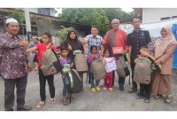 Mahfuz (tiga kanan) bergambar bersama beberapa penerima bantuan Program Kembali ke Sekolah anjuran Pertubuhan Peduli Aman di Langgar pada Sabtu.