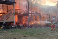 Bomba sedang memadam kebakaran sebuah rumah dan tujuh kenderaan termasuk lima motosikal musnah dalam kebakaran di Kampung Gong Duek di Hulu Besut petang semalam. Foto JBPM