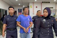 Tertuduh diiringi anggota polis ketika dibawa ke Mahkamah Butterworth, pada Selasa.