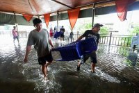 Kakitangan Koperasi Pelancongan Mukim Batu Putih Kinabatangan Bhd (KOPEL) mengalihkan peralatan ke tempat selamat selepas limpahan air dari Sungai Kinabatangan memasuki dewan makan pusat pelancongan itu ketika tinjauan di Kampung Mengaris 1, pada Khamis. Foto Bernama