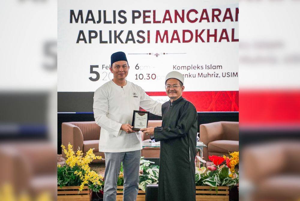 USTAZ AMINUDDIN (kiri) menyampaikan cenderamata kepada Dr Mohamad Sabri pada Majlis Pelancaran Aplikasi Madkhal di Kompleks Islam Tuanku Mukhriz, USIM baru-baru ini. 