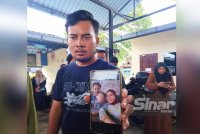 Mohammad Afiq Akhmal menunjukkan fotonya bersama isteri dan anak lelakinya berusia lima tahun.