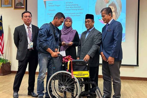 Abdul Rahman (dua dari kanan) diiringi Dr Zaini (kanan) dan Dr Imi Sairi (kiri) menyampaikan sumbangan kerusi roda kepada waris pesakit.