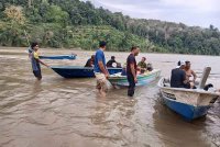 Penduduk kampung turut membantu operasi pencarian di lokasi kejadian menggunakan bot nelayan. Foto: Bomba Perak