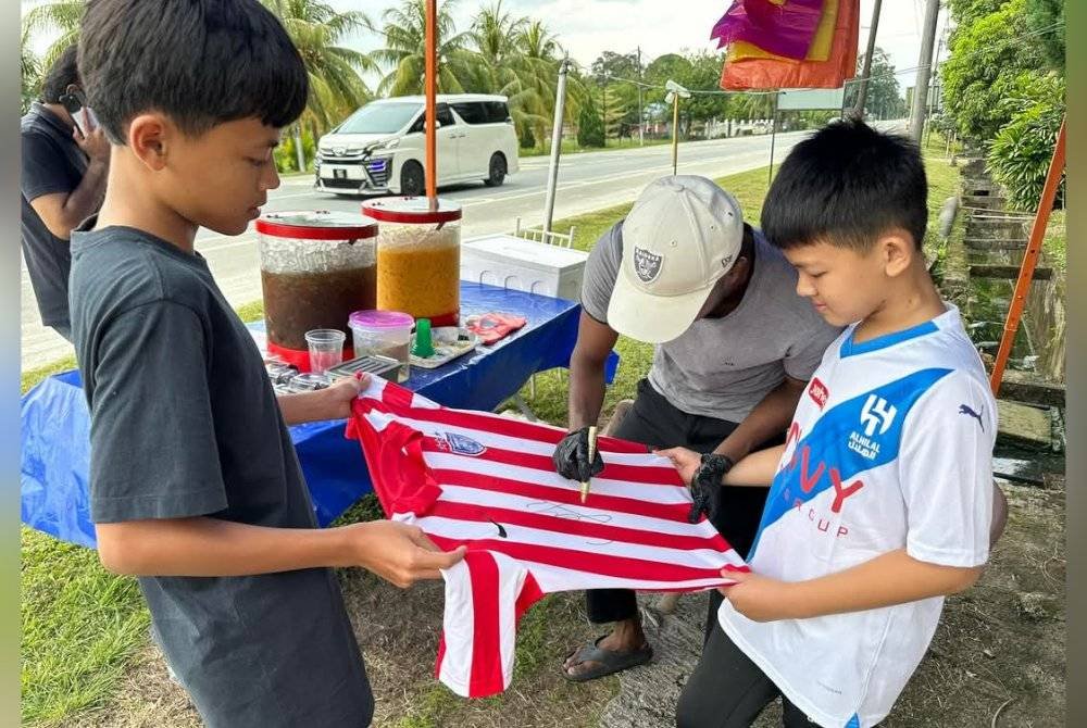 Dua peminat cilik tidak melepaskan peluang mendapatkan tandatangan Gopi.