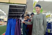 Muhammad Zaqeef (kanan) bersama rakan-rakan dari Pertubuhan Baitul Aini Anak-Anak Yatim dan Miskin Ipoh memilih pakaian di Pasar raya Econsave Klebang di Ipoh.