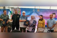 Wan Rosdy (tiga dari kiri) menyerahkan sijil penyertaan kepada wakil peserta yang menyertai Program Gerak Rahmah:Jom Masak Bubur Lambuk Perpaduan Peringkat Negeri Pahang di Kampung Tanjung Gahai, Lipis pada Ahad.