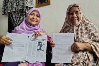 Sarimah (kanan) menunjukkan surat yang ditulis kepada Mohd Na&#039;im.