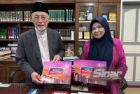 Mohamad Shukri (kiri) dan Surena (kanan) memegang risalah penerangan berkait Surah As-Saff. FOTO SINAR HARIAN-ADILA SHARINNI WAHID