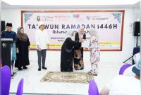 Fauzilah (kanan) menyampaikan Ramadan Box pada salah seorang penerima di Masjid UniSZA, Kuala Nerus.