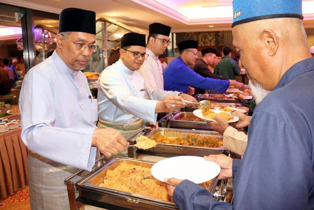 MOHAMED RAFIK (kiri) menyantuni tetamu dalam majlis yang diadakan pada Sabtu. 