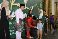 Nik Fauzan (tiga dari kiri) sambil diperhatikan Reime Rizal (dua dari kiri) menyerahkan sumbangan duit raya kepada anak-anak asnaf dan yatim daripada MTD Properties semasa Majlis Kasih Ramadan di Masjid Taman Sutera, Kajang di sini pada Sabtu.